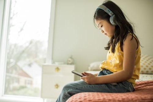 A child looking at social media on her phone.